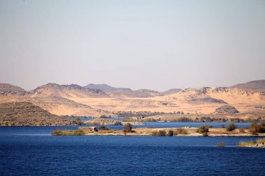 Mısır 'daki Nasser Gölü kıyısındaki dağlar ve çöller. Nasser Gölü, Aswan Barajı 'nın soyutlanmasıyla kuruldu.