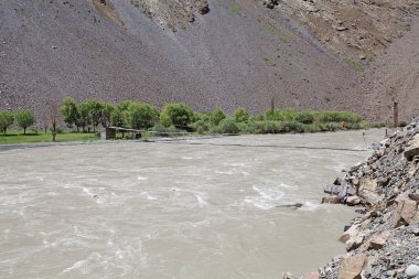 Tacikistan 'daki Gorno-Badakhshan' daki Bartang Nehri boyunca uzanan Tibet köprüsü ve manzarası. Badakhshan, Tacikistan 'ın doğusunda, Pamir Dağları' nda özerk bir bölgedir.