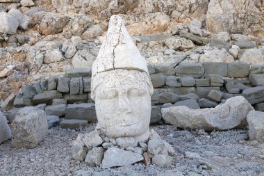 Türkiye 'nin güneyindeki Nemrut Dağı' nın doğu terasında tahtlar. Nemrut Dağı, MÖ 1. yüzyıldan kalma bir kraliyet mezarı olduğu düşünülen bir takım büyük heykellerin dikildiği zirve için dikkat çekicidir.. 