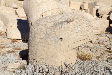 Türkiye 'nin güneyindeki Nemrut Dağı' nın doğu terasında tahtlar. Nemrut Dağı, MÖ 1. yüzyıldan kalma bir kraliyet mezarı olduğu düşünülen bir takım büyük heykellerin dikildiği zirve için dikkat çekicidir.. 