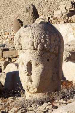 Türkiye 'nin güneyindeki Nemrut Dağı' nın doğu terasında tahtlar. Nemrut Dağı, MÖ 1. yüzyıldan kalma bir kraliyet mezarı olduğu düşünülen bir takım büyük heykellerin dikildiği zirve için dikkat çekicidir.. 