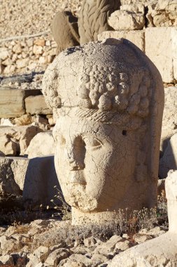 Türkiye 'nin güneyindeki Nemrut Dağı' nın doğu terasında tahtlar. Nemrut Dağı, MÖ 1. yüzyıldan kalma bir kraliyet mezarı olduğu düşünülen bir takım büyük heykellerin dikildiği zirve için dikkat çekicidir.. 