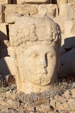 Türkiye 'nin güneyindeki Nemrut Dağı' nın doğu terasında tahtlar. Nemrut Dağı, MÖ 1. yüzyıldan kalma bir kraliyet mezarı olduğu düşünülen bir takım büyük heykellerin dikildiği zirve için dikkat çekicidir.. 