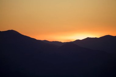 Türkiye 'nin güneyindeki Nemrut Dağı' ndan gün batımında manzara. Nemrut Dağı, MÖ 1. yüzyıldan kalma olduğu düşünülen kraliyet mezarının etrafına bir takım büyük heykellerin dikildiği zirve ile dikkat çekiyor. UNESCO World He olarak belirlendi.