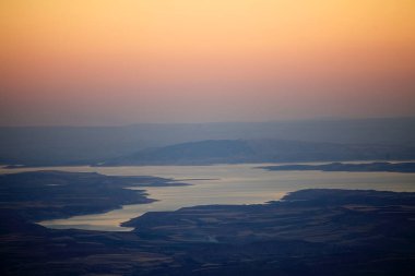 Türkiye 'nin güneyindeki Nemrut Dağı' ndan gün batımında manzara. Nemrut Dağı, MÖ 1. yüzyıldan kalma olduğu düşünülen kraliyet mezarının etrafına bir takım büyük heykellerin dikildiği zirve ile dikkat çekiyor. UNESCO World He olarak belirlendi.