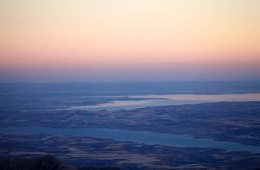Türkiye 'nin güneyindeki Nemrut Dağı' ndan gün batımında manzara. Nemrut Dağı, MÖ 1. yüzyıldan kalma olduğu düşünülen kraliyet mezarının etrafına bir takım büyük heykellerin dikildiği zirve ile dikkat çekiyor. UNESCO World He olarak belirlendi.