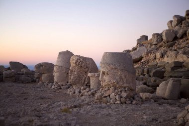Şafak vakti Türkiye 'nin güneyindeki Nemrut Dağı' nın doğu terasına doğru devasa bir yol alıyor. Nemrut Dağı, MÖ 1. yüzyıldan kalma olduğu düşünülen kraliyet mezarının etrafına bir takım büyük heykellerin dikildiği zirve ile dikkat çekiyor. Bu belirtilmişti.