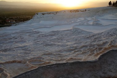 Gün batımında Pamukkale. Pamukkale Türkçe pamuk kale anlamına gelen Türkiye 'nin güneybatısında doğal bir alandır. Bu bölge termal kaynak suyunun akışından kalan karbonat mineraliyle ünlüdür.
