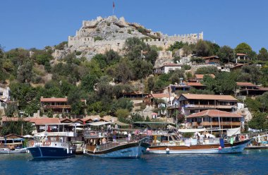 Güneyden Kalekoy köyündeki turist tekneleri görülürken, Türkiye 'nin merkezinde Bizans kalesi bulunuyor. Kalekoy Akdeniz 'de bir köydür.