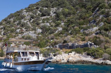 Türkiye 'nin Akdeniz kıyısındaki batık Simena ve Kekova adasının kalıntıları önünde bir turizm teknesi denize açılıyor