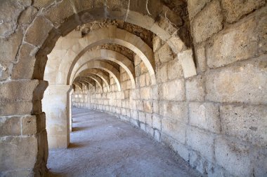 İzleyiciler için, Türkiye 'nin güneybatı Akdeniz kıyısındaki Antalya ilinde bulunan antik bir Greko-Romen kenti olan Aspendos kentindeki Roma tiyatrosunun merdivenlerinin altındaki geçit..