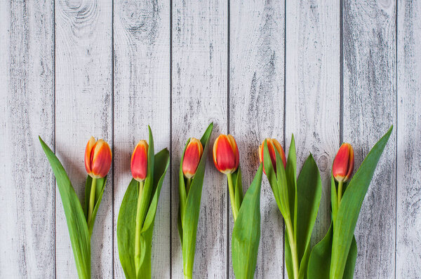 A bouquet of yellow and pink tulips on a wooden background