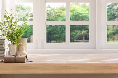 Boş ahşap masa, eski kitap ve vazoda bitkilerle dekore edilmiş pencere tarafından, bulanık yeşil arkaplanlı, 3 boyutlu.