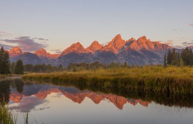 a beautiful sunrise landscape reflection in the Tetons in autumn