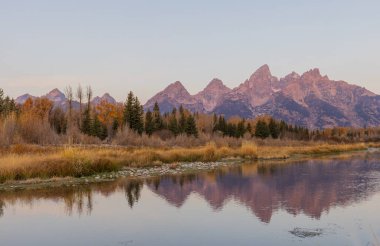 a scenic sunrise reflection in the Tetons in autumn