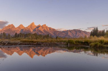 a beautiful sunrise landscape reflection in the Tetons in autumn