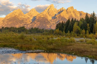 a beautiful sunrise landscape reflection in the Tetons in autumn