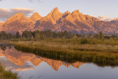 a beautiful sunrise landscape reflection in the Tetons in autumn