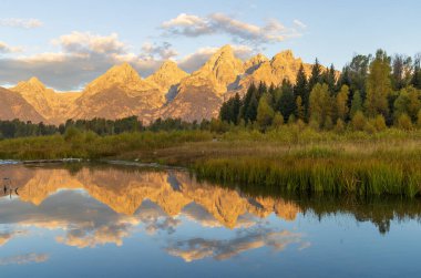 a beautiful sunrise landscape reflection in the Tetons in autumn