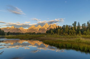 a beautiful sunrise landscape reflection in the Tetons in autumn