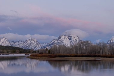 Tetonların ilkbaharda gün doğumunda manzaralı bir yansıması.