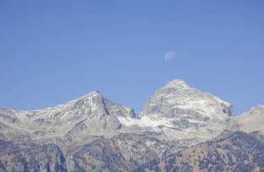 Grand Teton Ulusal Parkı Wyoming 'de manzaralı bir sonbahar manzarasının üzerinde bir ay.