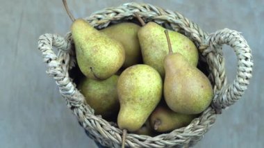 Ahşap bir arka planda sepetteki armutlar. Meyve hasadı. Sonbahar hala hayattır. Armut çeşitliliğinde Bera Konferansı. Vitamin yiyeceği..