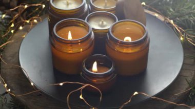 Soya mumları cam kavanozlarda yanar. Evdeki rahatlık. Kahverengi kavanozdaki mum. Koku ve ışık. Kokulu el yapımı mum. Aroma terapisi. Noel ağacı ve kış havası. Sıcak ev dekorasyonu. Şenlikli dekorasyon.