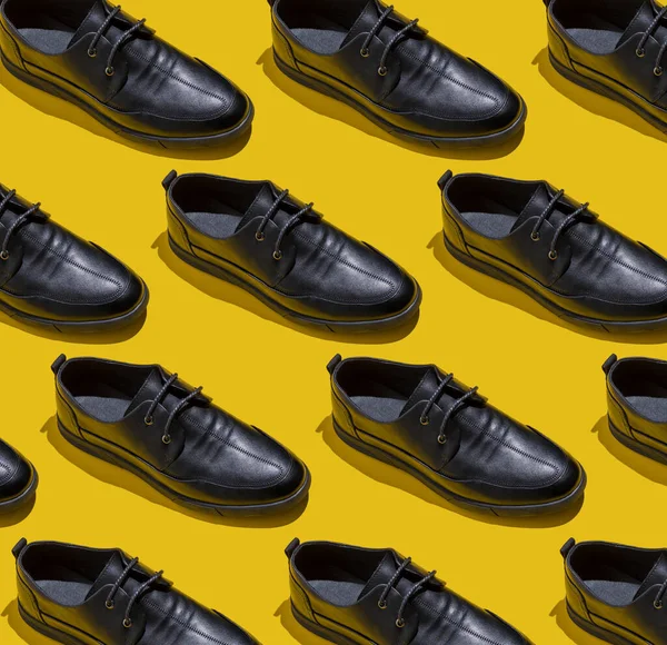 靴のパターン 影と黄色の背景上のビューに黒い靴 アクセサリーコンセプト 新しい革の靴 古典的なオフィススタイル メンズファッションシューズ フラットミニマリズムストア広告 — ストック写真