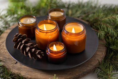 Soya mumları cam kavanozlarda yanar. Evdeki rahatlık. Kahverengi kavanozdaki mum. Koku ve ışık. Kokulu el yapımı mum. Aroma terapisi. Noel ağacı ve kış havası. Hoş bir dekor. Şenlikli dekorasyon