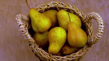 Ahşap bir arka planda sepetteki armutlar. Meyve hasadı. Sonbahar hala hayattır. Armut çeşitliliğinde Bera Konferansı. Vitamin yiyeceği..