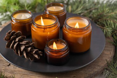 Soya mumları cam kavanozlarda yanar. Evdeki rahatlık. Kahverengi kavanozdaki mum. Koku ve ışık. Kokulu el yapımı mum. Aroma terapisi. Noel ağacı ve kış havası. Hoş bir dekor. Şenlikli dekorasyon
