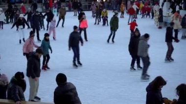 Ukrayna, Kyiv - 7 Ocak 2022: Kışın buz pateni pisti. İnsanlar paten kayıyor. Patenler buzda kayar. Buz pateni bir kış sporu eğlencesi. Noel zamanı. Noel ağacı Roshen fabrikası. Kalabalık