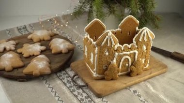 Noel 'de ev yapımı zencefilli kek. Zencefilli kurabiye adam. Beyaz kremalı astle. Noel ağacı şeklinde kurabiyeler ve masanın üstünde kar taneleri. Tatlı olarak yiyecek. Kış zencefilli ekmek.