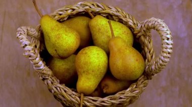 Ahşap bir arka planda sepetteki armutlar. Meyve hasadı. Sonbahar hala hayattır. Armut çeşitliliğinde Bera Konferansı. Vitamin yiyeceği..