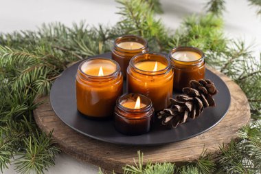 Soya mumları cam kavanozlarda yanar. Evdeki rahatlık. Kahverengi kavanozdaki mum. Koku ve ışık. Kokulu el yapımı mum. Aroma terapisi. Noel ağacı ve kış havası. Hoş bir dekor. Şenlikli dekorasyon