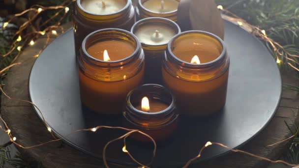 大豆蜡烛在玻璃瓶中燃烧 在家里很舒服把蜡烛放在棕色的罐子里 光芒四射有香味的手工蜡烛芳香疗法 圣诞树和冬天的心情 舒适的家居装饰 节日装饰 — 图库视频影像