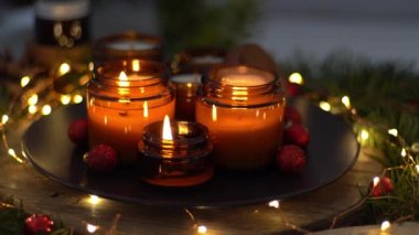 Soya mumları cam kavanozlarda yanar. Evdeki rahatlık. Kahverengi kavanozdaki mum. Koku ve ışık. Kokulu el yapımı mum. Aroma terapisi. Noel ağacı ve kış havası. Sıcak ev dekorasyonu. Şenlikli dekorasyon.