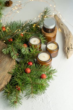 Soya mumları cam kavanozlarda yanar. Evdeki rahatlık. Kahverengi kavanozdaki mum. Koku ve ışık. Kokulu el yapımı mum. Aroma terapisi. Noel ağacı ve kış havası. Hoş bir dekor. Şenlikli çelenk dekorasyonu