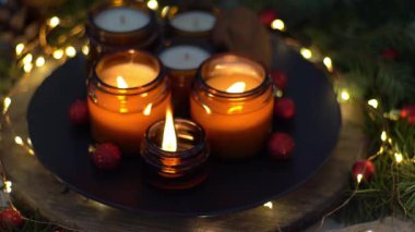Soya mumları cam kavanozlarda yanar. Evdeki rahatlık. Kahverengi kavanozdaki mum. Koku ve ışık. Kokulu el yapımı mum. Aroma terapisi. Noel ağacı ve kış havası. Sıcak ev dekorasyonu. Kırmızı toplar dekorasyonu