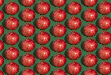 Nar deseni. Yeşil arka planda kırmızı nar. Meyve yemeği konsepti.