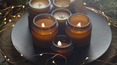 Soya mumları cam kavanozlarda yanar. Evdeki rahatlık. Kahverengi kavanozdaki mum. Koku ve ışık. Kokulu el yapımı mum. Aroma terapisi. Noel ağacı ve kış havası. Sıcak ev dekorasyonu. Şenlikli dekorasyon.