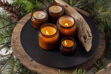 Soya mumları cam kavanozlarda yanar. Evdeki rahatlık. Kahverengi kavanozdaki mum. Koku ve ışık. Kokulu el yapımı mum. Aroma terapisi. Noel ağacı ve kış havası. Hoş bir dekor. Şenlikli dekorasyon