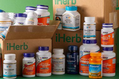 iHerb kutusundan vitaminler, mineraller ve mikro besinler. Bir sürü farklı kavanoz. Biyolojik olarak aktif gıda katkı maddeleri. Beslenme takviyesi çevrimiçi alınıyor. Sağlık için ilaçlar. Kyiv, Ukrayna - 13 Temmuz 2022