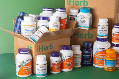 iHerb kutusundan vitaminler, mineraller ve mikro besinler. Bir sürü farklı kavanoz. Biyolojik olarak aktif gıda katkı maddeleri. Beslenme takviyesi çevrimiçi alınıyor. Sağlık için ilaçlar. Kyiv, Ukrayna - 13 Temmuz 2022