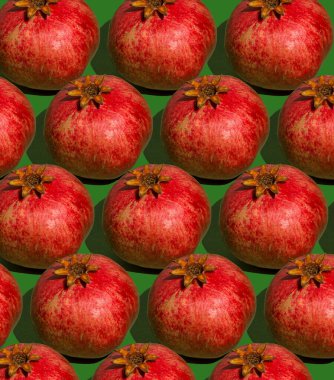 Nar deseni. Yeşil arka planda kırmızı nar. Meyve yemeği konsepti.