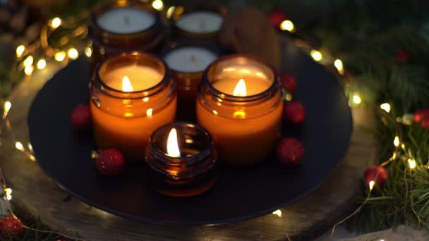 大豆キャンドルはガラス瓶で焼かれます 自宅での快適さ 茶色の瓶の中のキャンドル 香りと光 手作りのキャンドルを香り アロマセラピー クリスマスツリーと冬の気分 居心地の良い家の装飾 赤い玉飾り — ストック動画