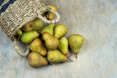 Ahşap bir arka planda sepetteki armutlar. Meyve hasadı. Sonbahar hala hayattır. Armut çeşitliliğinde Bera Konferansı. Vitamin yiyeceği..