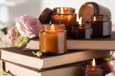 A set of different aroma candles in brown glass jars. Scented handmade candle. Soy candles are burning in a jar. Aromatherapy and relax in spa and home. Fire in brown jar.