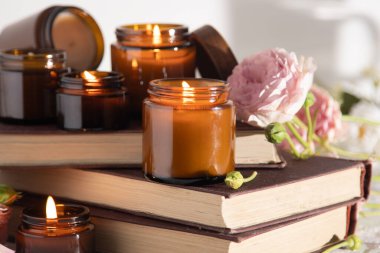 A set of different aroma candles in brown glass jars. Scented handmade candle. Soy candles are burning in a jar. Aromatherapy and relax in spa and home. Fire in brown jar.